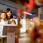 Familia disfrutando de una visita cultural en un museo de Madrid, observando obras y compartiendo una experiencia educativa juntos